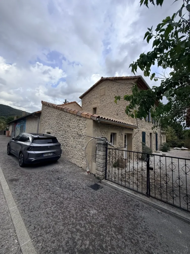 Vue depuis la rue de la maison en galets rénovée et de son portail